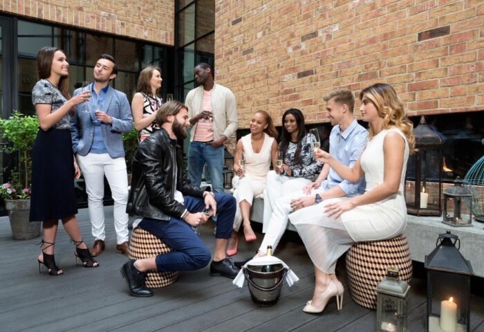 Hotel Zoo Berlin: Diverse group enjoying drinks. Gay-friendly, pet-friendly hotel with stylish decor. Celebrate diversity and inclusivity.
