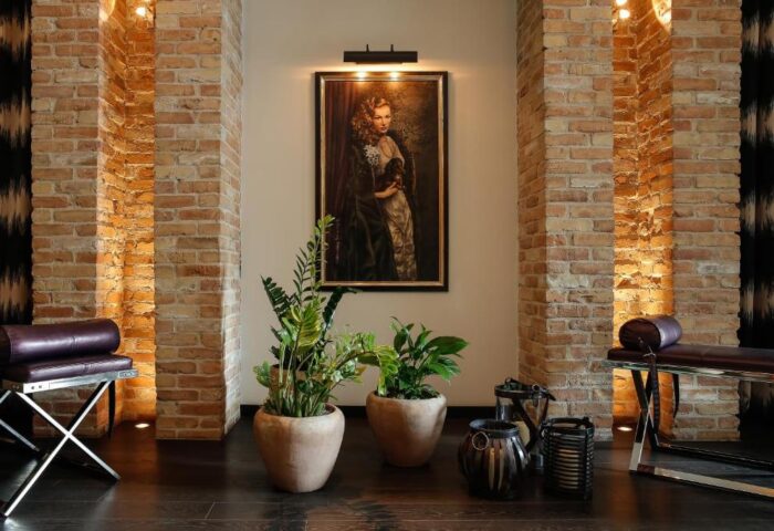 Hotel Zoo Berlin interior. Brick pillars, plants, and a portrait create a stylish ambiance. Gay-friendly, pet-friendly design.