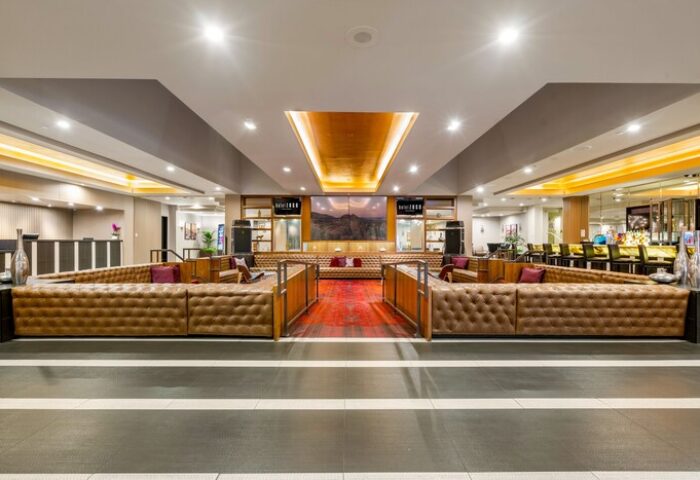 Hotel Zoso, a gay-friendly hotel: Lobby lounge area with tufted leather sofas and a red rug. A stylish space for gay travelers.