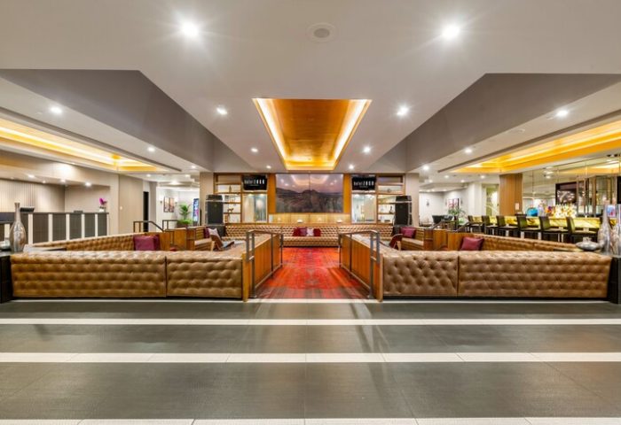 Hotel Zoso, a gay-friendly hotel: Lobby lounge area with tufted leather sofas and a red rug. A stylish space for gay travelers.