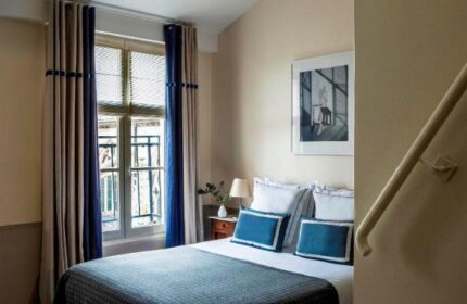 Hotel de la Place du Louvre gay-friendly room. Pet-friendly hotel room with double bed, blue accents, and natural light. Paris gay travel.