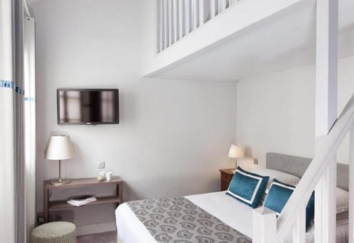Hotel de la Place du Louvre gay-friendly room. Pet-friendly hotel with a bed, TV, and loft. Perfect for gay travel in Paris.