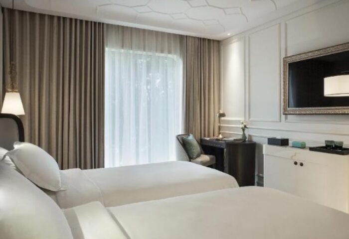 Hôtel des Arts Saigon MGallery Collection room. Gay-friendly hotel with twin beds, desk, and TV. Luxury travel for gay men.