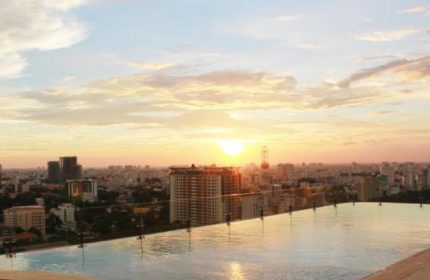 Sunset view from Hôtel des Arts Saigon MGallery Collection rooftop pool. Gay-friendly hotel in Saigon, Vietnam. Cityscape, travel.