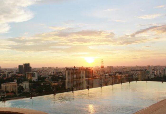 Sunset view from Hôtel des Arts Saigon MGallery Collection rooftop pool. Gay-friendly hotel in Saigon, Vietnam. Cityscape, travel.