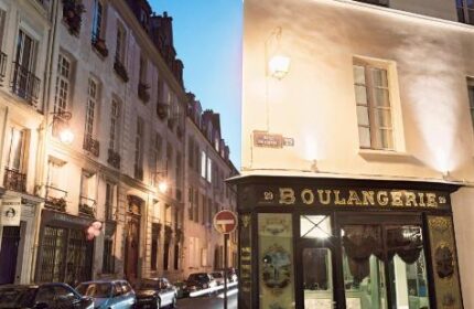 Hotel du Petit Moulin, a gay-friendly hotel in Paris. Street view with Boulangerie. A charming Parisian scene for gay travelers.