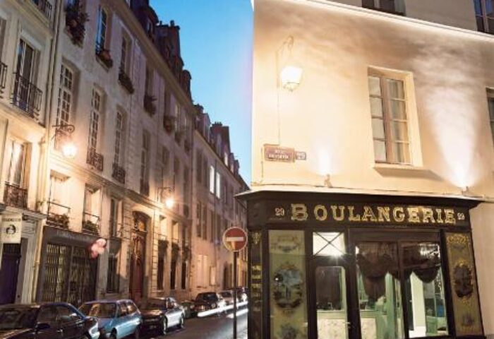 Hotel du Petit Moulin, a gay-friendly hotel in Paris. Street view with Boulangerie. A charming Parisian scene for gay travelers.