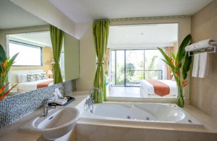 Hula Hula Resort Ao Nang gay-friendly hotel room. Bathtub, sink, and bedroom view. Modern design, green accents, and natural light.