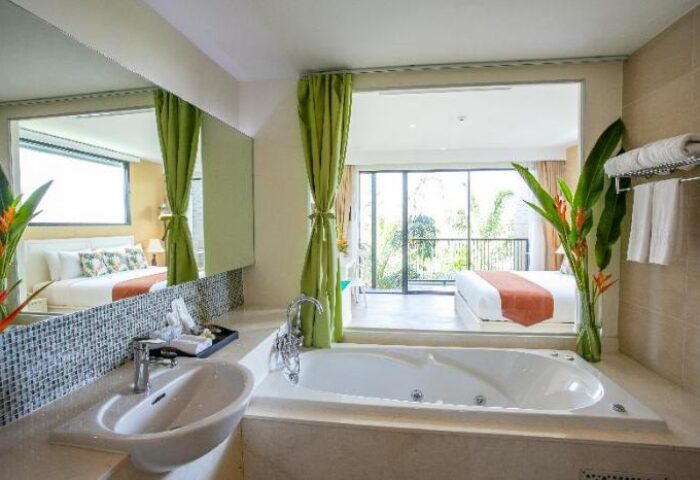 Hula Hula Resort Ao Nang gay-friendly hotel room. Bathtub, sink, and bedroom view. Modern design, green accents, and natural light.