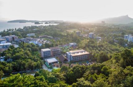 Aerial view of Hula Hula Resort, a gay-friendly hotel in Ao Nang, Thailand. Lush greenery surrounds the resort near the coast.