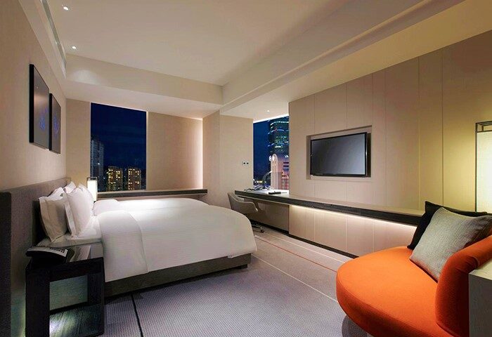 Humble House Taipei hotel room. Modern interior, bed, city view. Gay-friendly hotel for LGBTQ+ travelers in Taipei. Stylish design, comfortable stay.