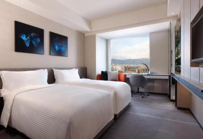 Humble House Taipei gay-friendly hotel room with twin beds, desk, city view, butterfly art. Modern design for gay travelers in Taipei.