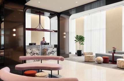 Hyatt Centric Montreal's lobby. A gay-friendly hotel featuring a marble reception desk, modern seating, and stylish decor for LGBTQ+ travelers.