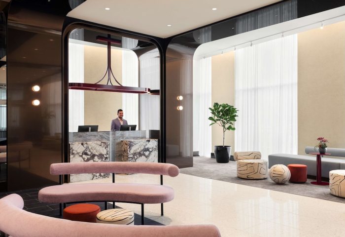 Hyatt Centric Montreal's lobby. A gay-friendly hotel featuring a marble reception desk, modern seating, and stylish decor for LGBTQ+ travelers.