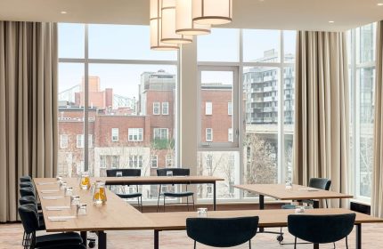Hyatt Centric Montreal's meeting room with city view. Gay-friendly hotel offers modern spaces for events. Stylish design, natural light.
