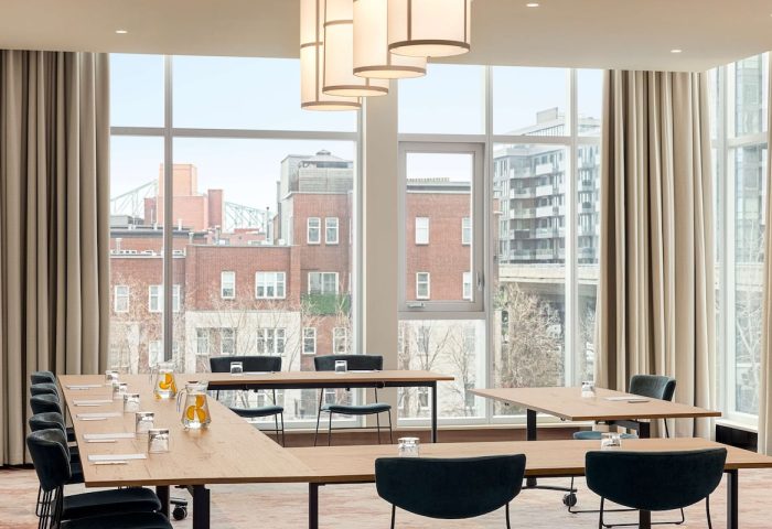 Hyatt Centric Montreal's meeting room with city view. Gay-friendly hotel offers modern spaces for events. Stylish design, natural light.