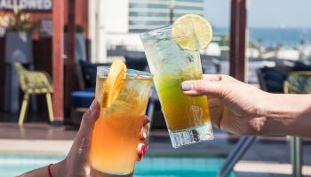 Cheers at Hyatt Centric The Pike Long Beach, a gay-friendly hotel. Cocktails by the pool offer a refreshing, inclusive vibe for gay travelers.