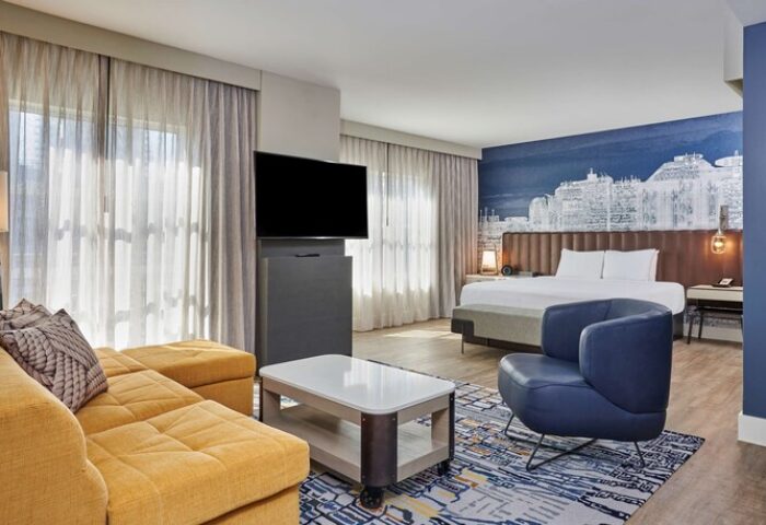 Hyatt Centric The Pike Long Beach hotel room. Gay-friendly travel suite with sofa, bed, and city view. Modern hotel for gay men's vacation.