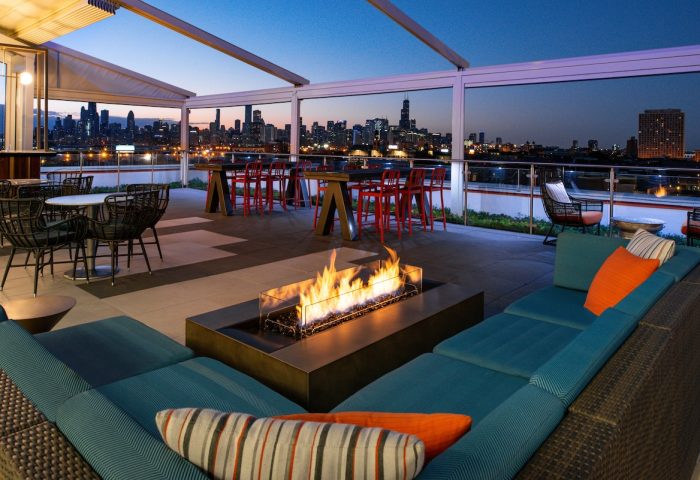 Hyatt Place Chicago/Wicker Park rooftop terrace at night. Fire pit, seating, and skyline views. Gay-friendly hotel for gay men travel advice.