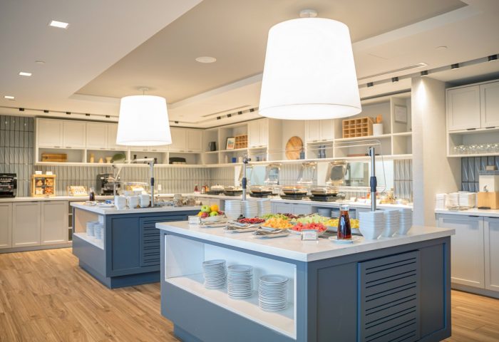 Breakfast buffet at Hyatt Place Montreal Downtown, a gay-friendly hotel. Fresh fruit, plates, and stylish lighting.