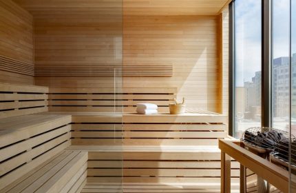 Sauna at Hyatt Place Montreal Downtown, a gay-friendly hotel. Features wooden benches, glass partition, towels, and a city view.