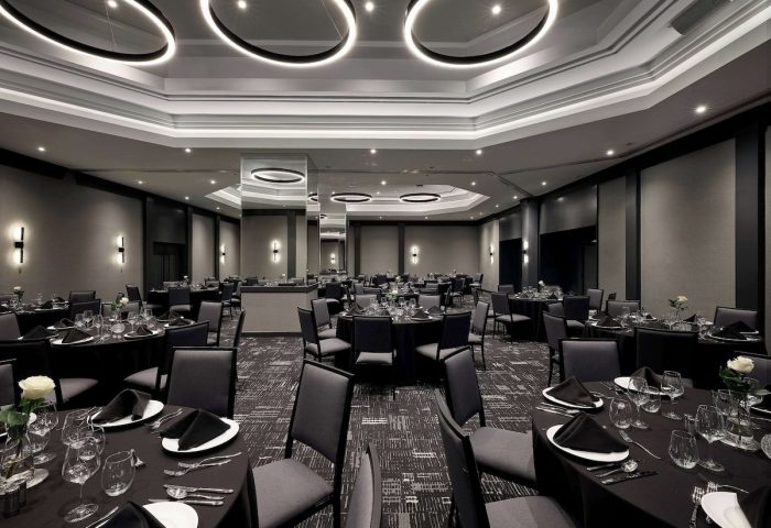 Elegant event space at Hyatt Place Montreal Downtown. Round tables with black linens, set for a formal dinner. Gay-friendly hotel venue.