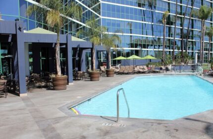 Hyatt Regency Long Beach pool area. Gay-friendly hotel with outdoor pool, lounge chairs, and palm trees. A perfect spot for gay travelers.