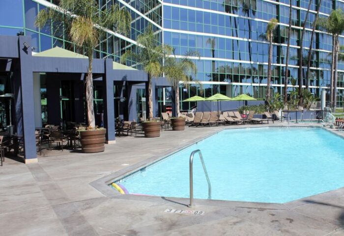 Hyatt Regency Long Beach pool area. Gay-friendly hotel with outdoor pool, lounge chairs, and palm trees. A perfect spot for gay travelers.