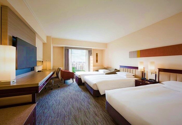 Hyatt Regency Tokyo hotel room with three beds. Gay-friendly hotel with city views, desk, and modern design. Ideal for gay travel in Tokyo.