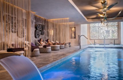 Hyatt Zilara Cancun gay-friendly hotel spa. Couple relaxing poolside in lounge chairs. Luxury travel for gay men in Cancun.