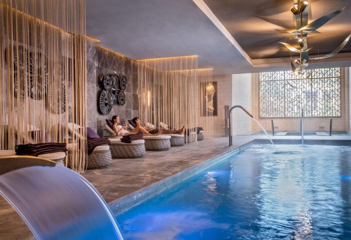 Hyatt Zilara Cancun gay-friendly hotel spa. Couple relaxing poolside in lounge chairs. Luxury travel for gay men in Cancun.