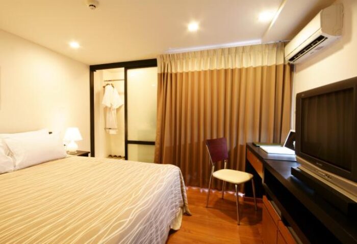 I Residence Hotel Sathorn room. Gay-friendly hotel featuring a bed, wardrobe, desk, and TV. Comfortable stay for gay travelers in Bangkok.