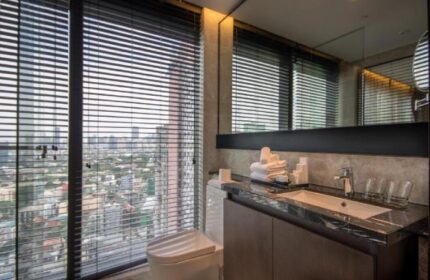 Bathroom in I'M Hotel, a gay-friendly hotel. Sink, toilet, and a large window with city views. Modern design. Gay travel.