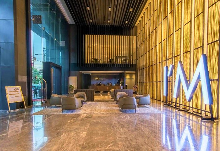 I'M Hotel lobby, a gay-friendly hotel. Modern design with marble floors, stylish seating, and the illuminated I'M logo. Perfect for gay travel.