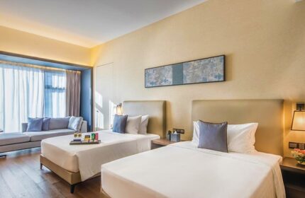 I'M Hotel's gay-friendly room: two beds, sofa, and modern decor. A welcoming space for gay travelers seeking comfort and style.