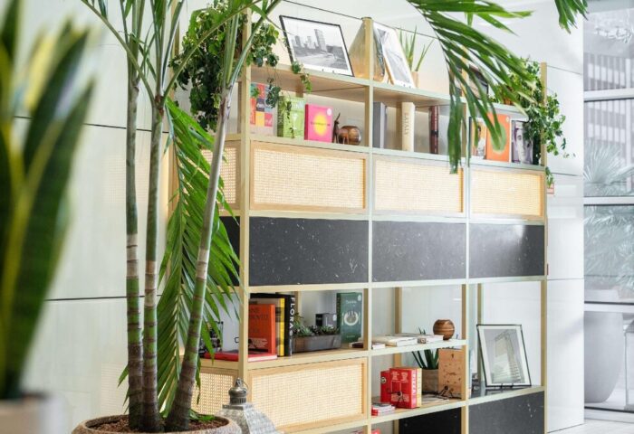 INNSiDE Milano Torre Galfa's stylish interior. Bookshelf with books, plants, & decor. Gay-friendly hotel design, inviting atmosphere.