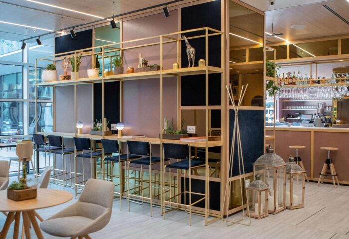 INNSiDE Milano Torre Galfa's stylish bar area. This gay-friendly hotel features modern design, bar stools, shelving, and a relaxed atmosphere.