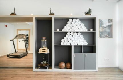 INNSiDE Milano Torre Galfa gay-friendly hotel gym. Towels stacked on shelves, water dispenser, treadmills. Wellness for gay travelers.