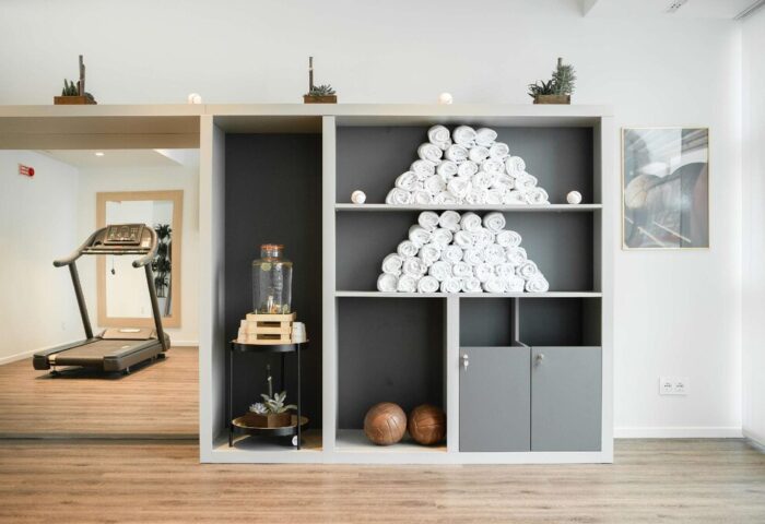 INNSiDE Milano Torre Galfa gay-friendly hotel gym. Towels stacked on shelves, water dispenser, treadmills. Wellness for gay travelers.