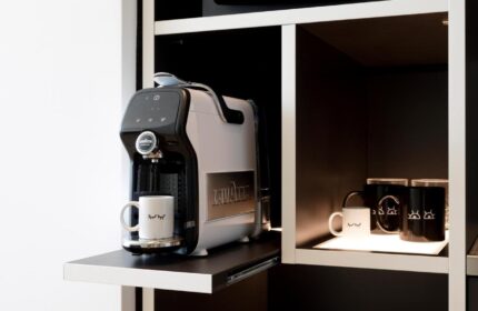 INNSiDE Milano Torre Galfa gay-friendly hotel room detail: Lavazza coffee maker and mugs on a shelf. Modern design, perfect for gay travelers.