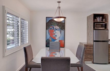 INNdulge Iconic Gay Men's Resort dining area. Modern art, table, chairs, mini fridge, and microwave. Gay-friendly hotel interior.