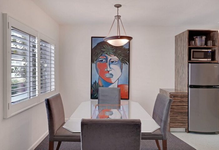 INNdulge Iconic Gay Men's Resort dining area. Modern art, table, chairs, mini fridge, and microwave. Gay-friendly hotel interior.
