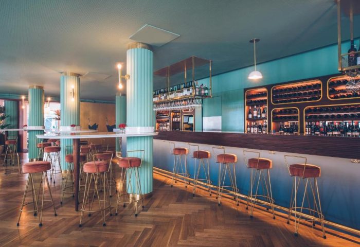 Iberostar Las Letras Gran Via's stylish bar area. Pet-friendly, gay-friendly hotel with unique decor. Bar stools, wine rack, and modern design.