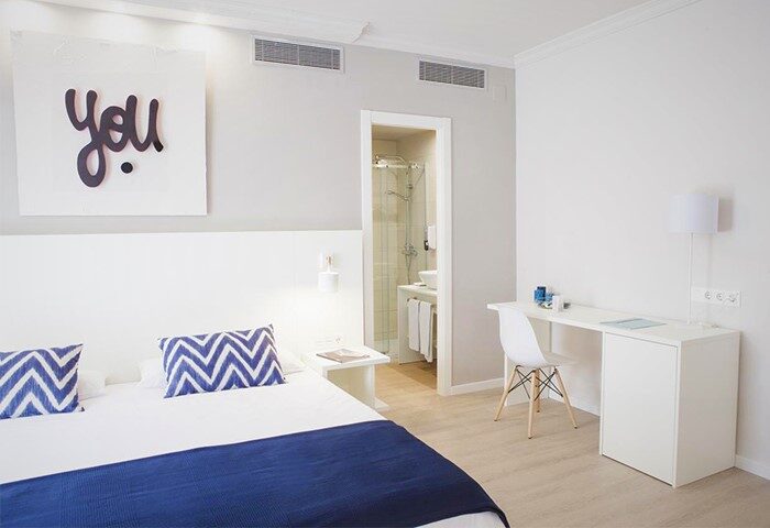 Ibersol Antemare Adults Only gay-friendly hotel room. Clean, modern design with blue accents. Desk, bed, and bathroom visible.
