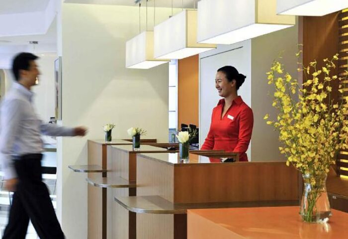 Ibis Beijing Dongdaqiao Hotel lobby. Smiling receptionist at the front desk. Gay-friendly hotel in Beijing, China. Modern interior.