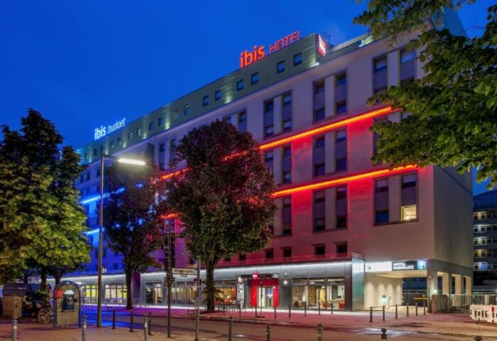 Ibis Berlin Kurfuerstendamm hotel exterior at night. Gay-friendly hotel with colorful lights. Berlin travel for gay men.