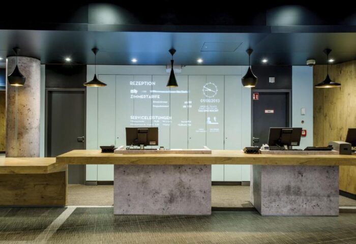 Ibis Berlin Kurfuerstendamm's reception area. This gay-friendly hotel features modern design, info screens, and stylish pendant lights.