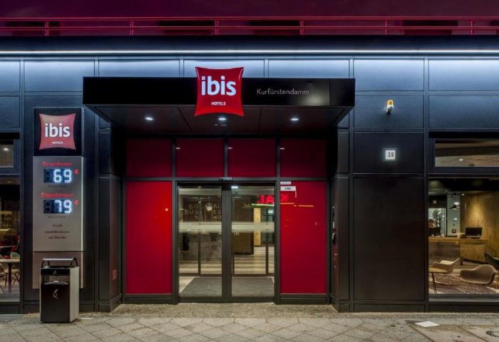 Ibis Berlin Kurfuerstendamm entrance. Gay-friendly hotel with modern facade and red accents. A welcoming spot for gay travelers in Berlin.