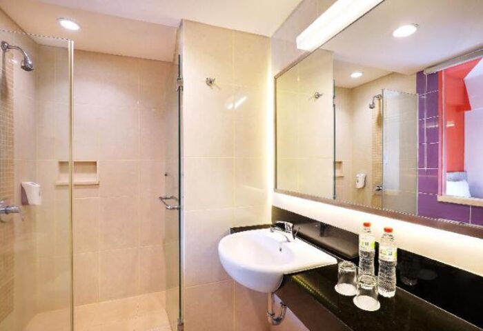 Ibis Budget Bali Seminyak bathroom. Shower, sink, mirror, and toiletries. Gay-friendly hotel for gay men travelers in Bali.