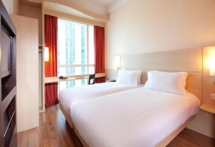 Ibis Hong Kong Central & Sheung Wan Hotel room. Gay-friendly hotel with twin beds, desk, and city view. Modern design, comfortable stay.